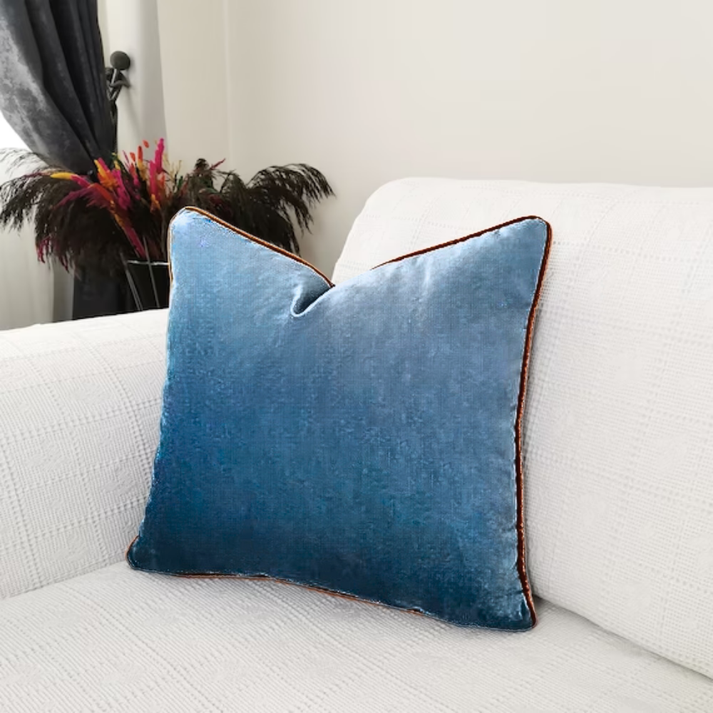 Blue decorative pillow sitting on couch