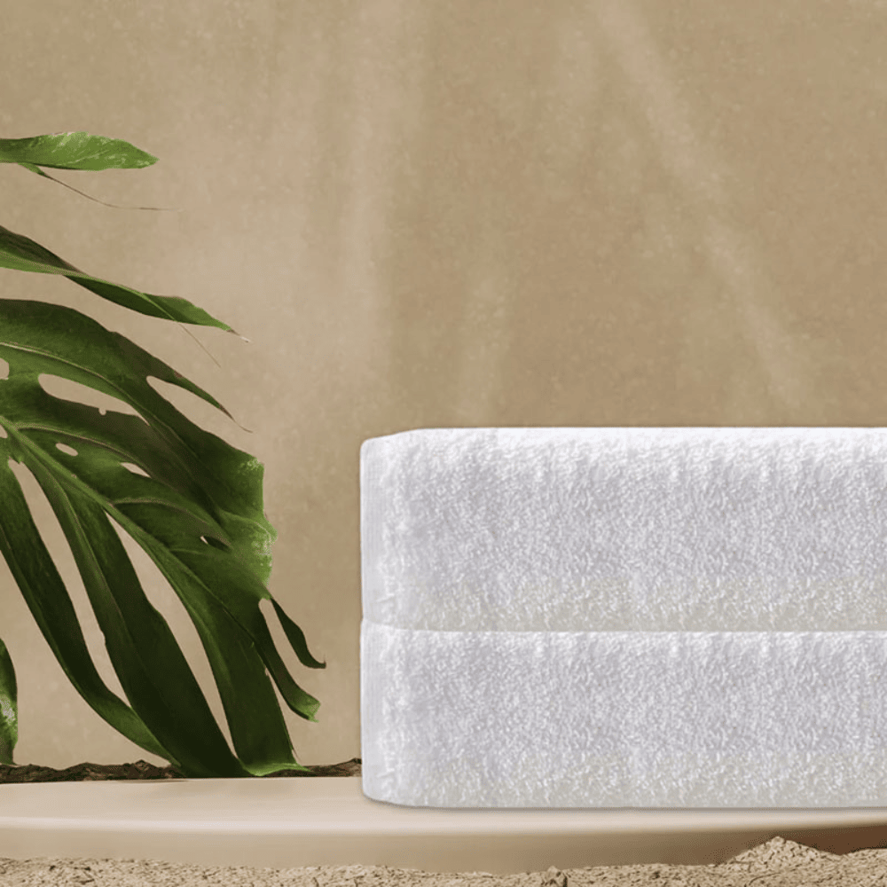 Luxury cotton towels wholesale - White towel and green plant.