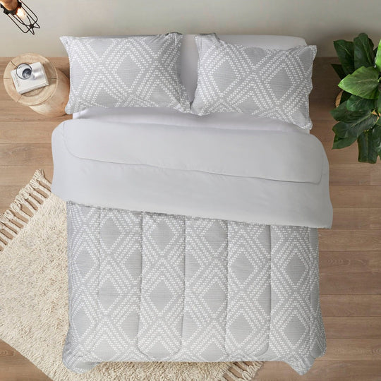 A cozy bed with a stylish gray and white comforter Eco-friendly cooling duvet crafted with lightweight materials and orthopedic support, designed for premium comfort in luxury hotel chain suites