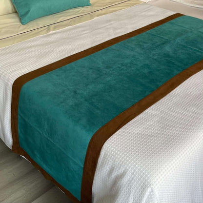 A bed with white sheets and toward the end of the bed there is a custom reversible bed scarf/ runner in brown and turquoise.